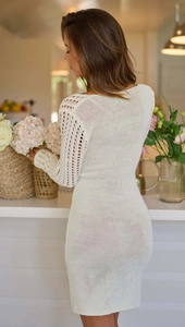 Détail d'une robe en maille blanche avec manches élégantes en dentelle crochetée