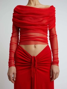 Close-up of red ruched mesh texture and off-shoulder detail on a two-piece set