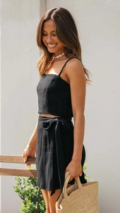 Detail of black two-piece summer set with spaghetti strap crop top and wrap tie skirt