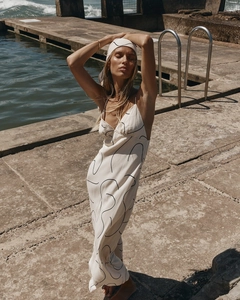 Detailed texture of off-white summer dress with black abstract print and fine spaghetti straps
