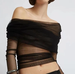 Detail of off-shoulder sheer mesh long sleeve top featuring elegant ruched draping design