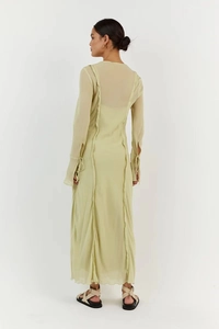 Rear view detail of a lime green chiffon dress with back seam and tied split cuffs