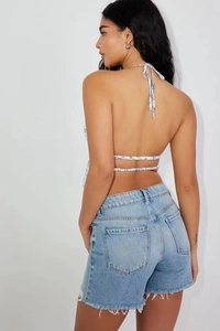Detail view of floral halter crop top with back tie and frayed denim shorts outfit