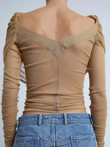 Detail of ruched mesh long sleeve top featuring an open back and sheer khaki fabric