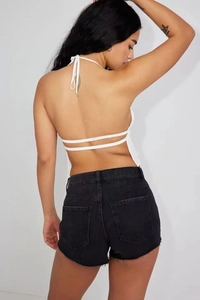 Detail view of white halter neck backless top with thin straps and double back ties