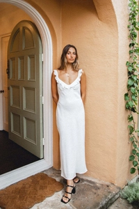 Detail of white maxi dress featuring delicate ruffle neckline and thin shoulder straps
