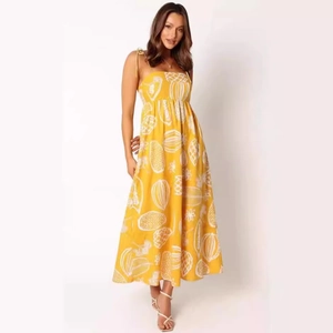 Detail of yellow floral midi dress with thin straps and vibrant tropical fruit pattern