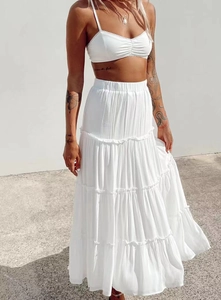 Detail of bohemian white tiered maxi skirt with high waist and lightweight texture