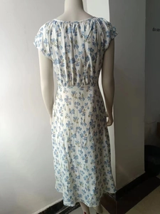Back view of a white floral dress with blue flowers, U-neck, and high waist design
