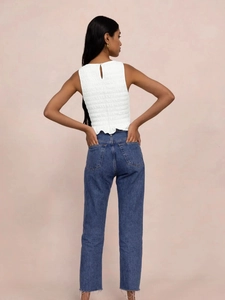 Detail view of the smocked white sleeveless top featuring back keyhole button closure