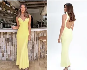 Dettaglio di un elegante abito lungo in raso giallo con scollo a V e schiena scoperta