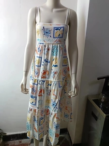 Detail of white floral sundress with vibrant fruit prints and tiered ruffle skirt hem