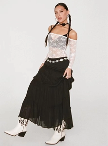 Detail of layered black tiered skirt with turquoise waist chain and white cowboy boots