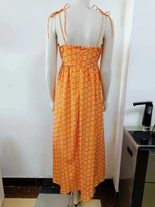 Detail of orange geometric print maxi dress showing back zipper and shoulder tie knots