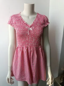 Detail of red gingham bodysuit with elastic smocked chest and white ribbon bow detail