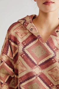 Close-up of bohemian geometric print on women's oversized hoodie with V-neck detail