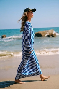 Relaxed blue and white striped maxi dress with long sleeves and side pockets on beach