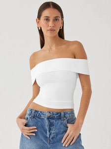 White off-the-shoulder slim fit knitted crop top paired with casual blue denim jeans