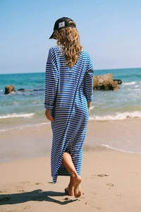 Detail of blue and white striped long sleeve dress featuring a relaxed fit at the beach