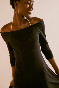 Detail of the black off-the-shoulder knitted dress showing fabric texture and neckline