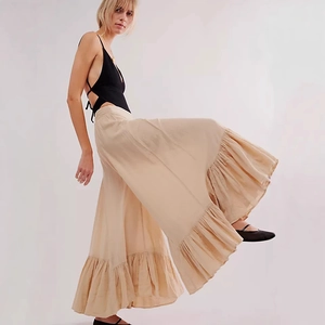 Detail of beige tiered ruffle maxi skirt with pleated texture and bohemian flair