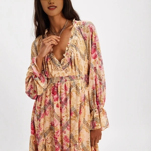 Close-up of V-neck ruffle neckline and pink floral print on beige long sleeve dress