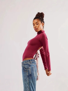 Détail du body bordeaux avec dos nu et ruban de soie floral noué pour un style élégant