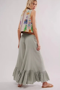 Detailed back view of a beige vest with ethnic embroidery and green flare wide-leg trousers