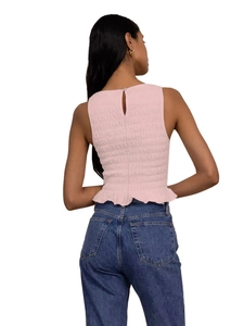 Rear view of pink ruched sleeveless top with elastic ruffles and blue denim jeans