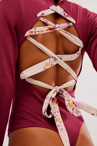 Gros plan sur un body bordeaux avec dos nu et lacets croisés à motifs colorés