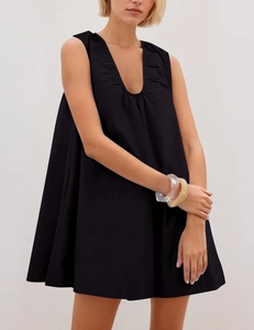 Close-up of pleated U-neckline and smooth fabric on black sleeveless A-line dress