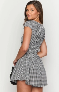 Detail view of smocked gingham romper featuring ruffled edges and high elasticity