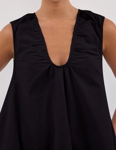 Detail of elegant black V-neckline with delicate pleated ruffles on a summer A-line dress