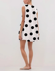 Detail of A-line sleeveless dress featuring vintage black polka dots on white fabric