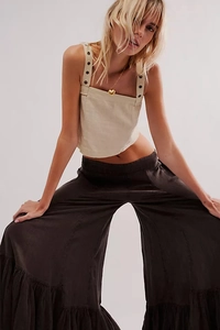 Detail shot of wide-leg flare pants in coffee brown with beige crop top and heart necklace