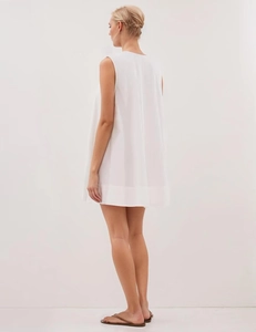Back view of a minimalist white sleeveless A-line dress with a clean and elegant drape