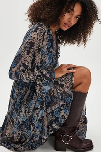 Close-up of bohemian floral V-neck dress paired with stylish dark brown leather boots