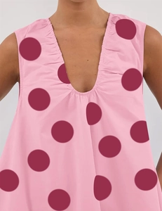 Detailed close-up of V-neckline with delicate ruffles and large burgundy polka dots