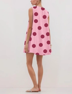 Detail of pink A-line sleeveless dress featuring dark red polka dot pattern and soft fabric