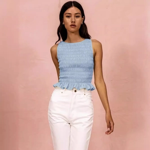 Slim fit light blue smocked sleeveless top with ruffle hem for women in spring 2025