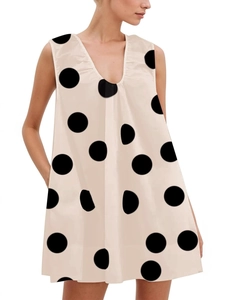 Minimalist V-neck sleeveless A-line dress with bold black polka dots on beige fabric