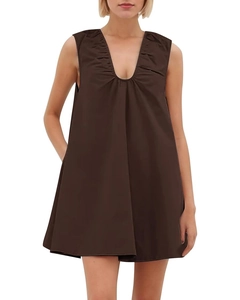Detail of V-neck pleats on a dark brown sleeveless A-line dress with structured cotton fabric
