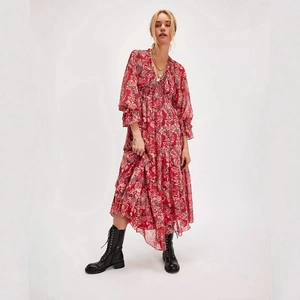 Detail of red floral V-neck dress with pleated hem and vintage flower patterns