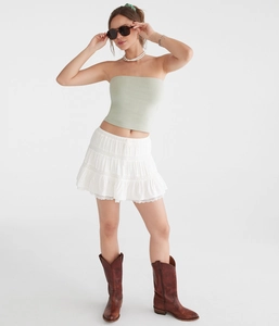 Detail of delicate lace trim on tiered white mini skirt with high-waist A-line ruffles