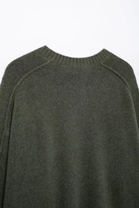 Détail de l'encolure ronde et des manches raglan sur ce pull en maille vert olive foncé