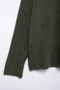 Détail du pull en tricot vert forêt avec ourlet côtelé et texture en laine douce