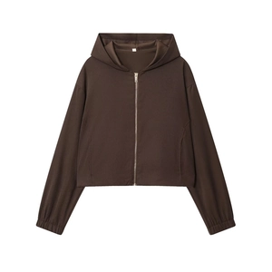 Detail eines braunen, kurzen Zip-Hoodies mit feiner Stoffstruktur und elastischen Bündchen