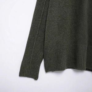 Pull en maille vert foncé avec poignets côtelés classiques et texture laine de qualité