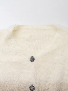 Détails de gilet en maille duveteuse blanc cassé avec des boutons en argent vintage gravés