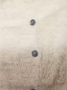 Détail macro de la maille ombrée pelucheuse avec bouton argenté vintage gravé